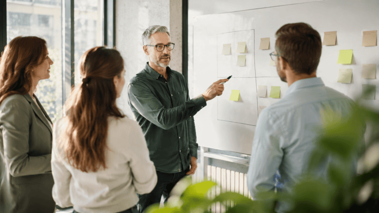 Unternehmer machen eine Wesentlichkeitsanalyse an einer Tafel